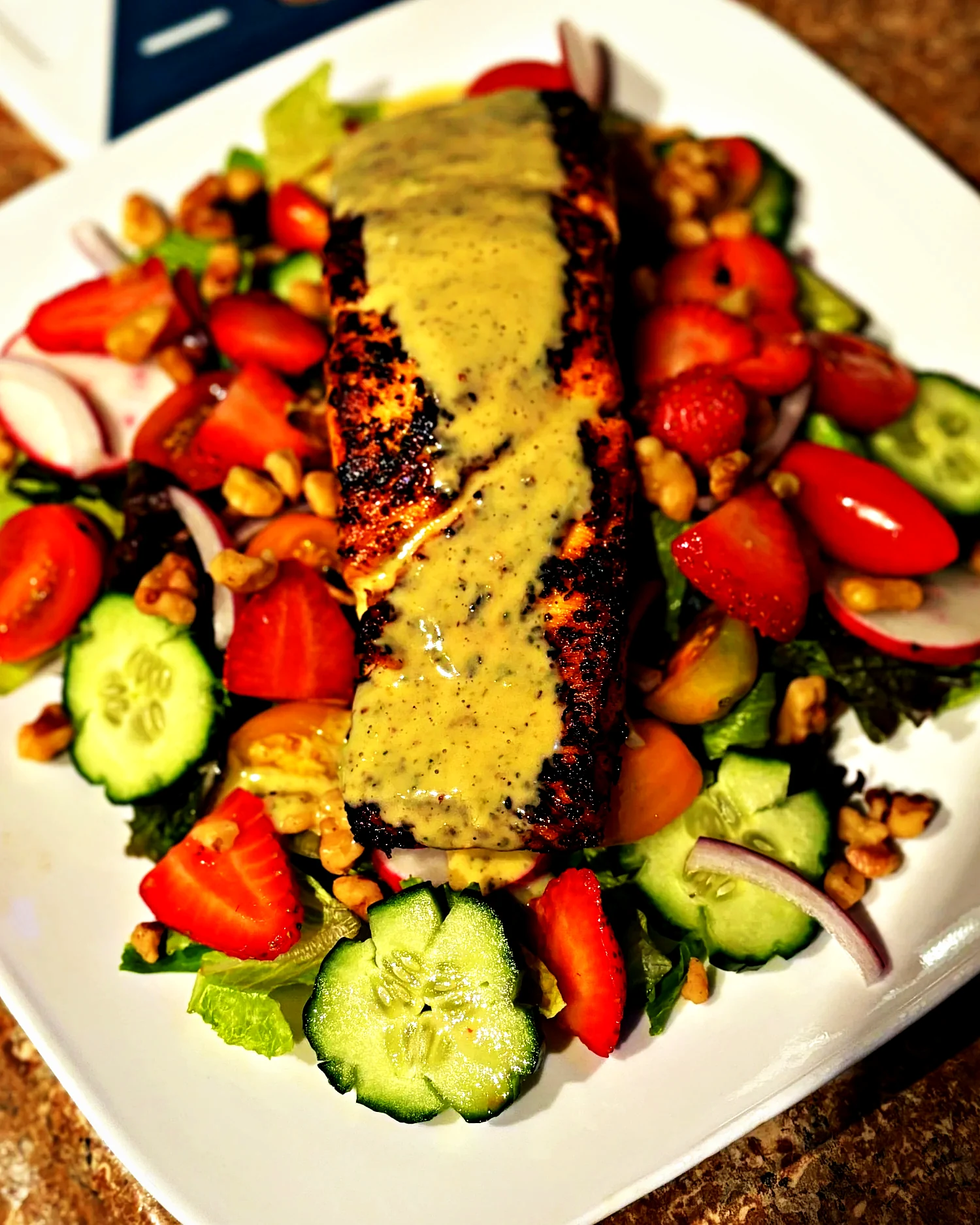 Blackened salmon over strawberry salad with lemon poppyseed vinaigrette