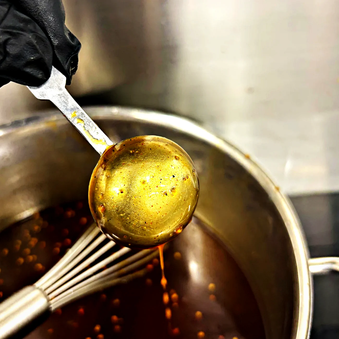 Lemon poppyseed vinaigrette on a ladle